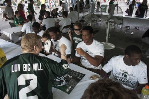 Defensive end William Gholston interacts with a fan wearing his jersey during the Meet the Spartans event.