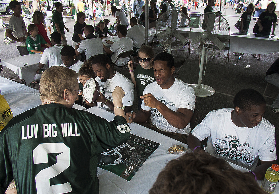Defensive end William Gholston interacts with a fan wearing his jersey during the Meet the Spartans event.